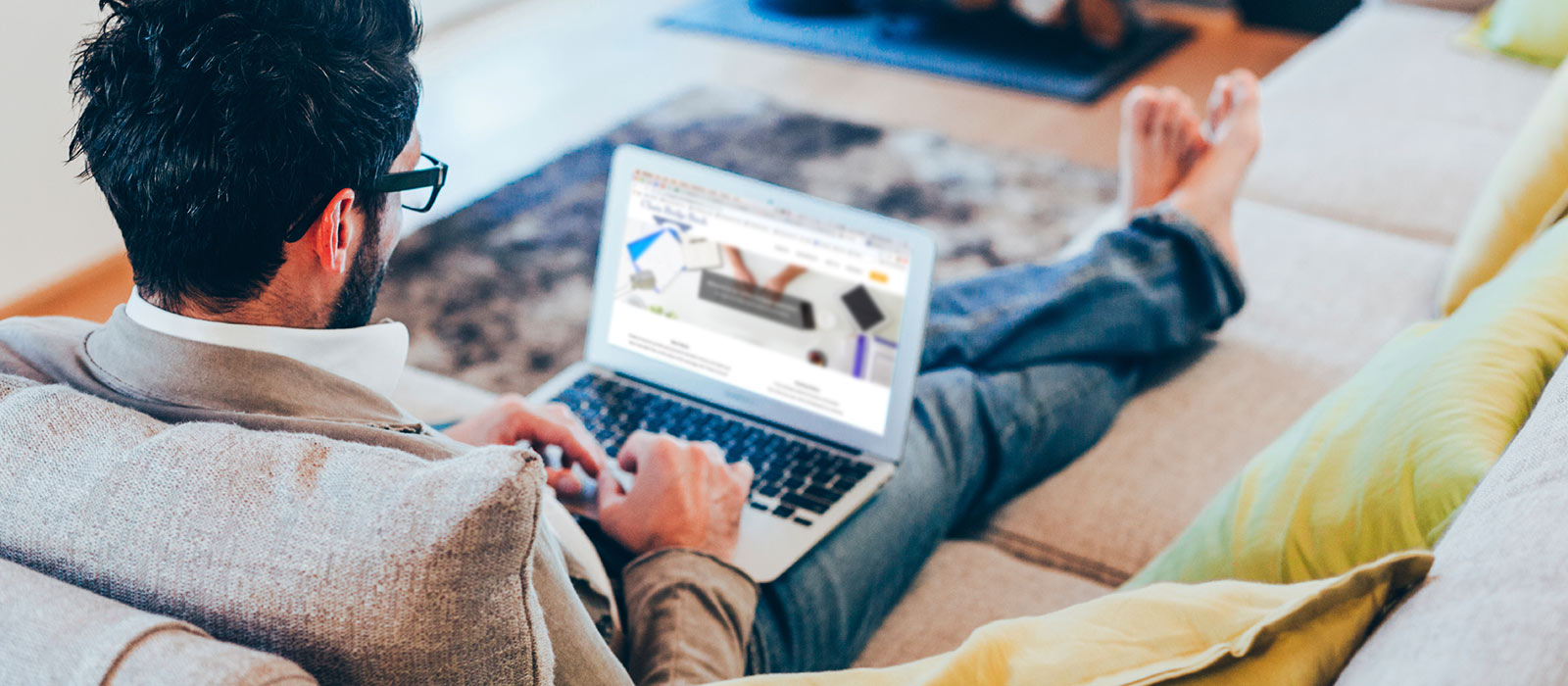 Man using laptop on couch.