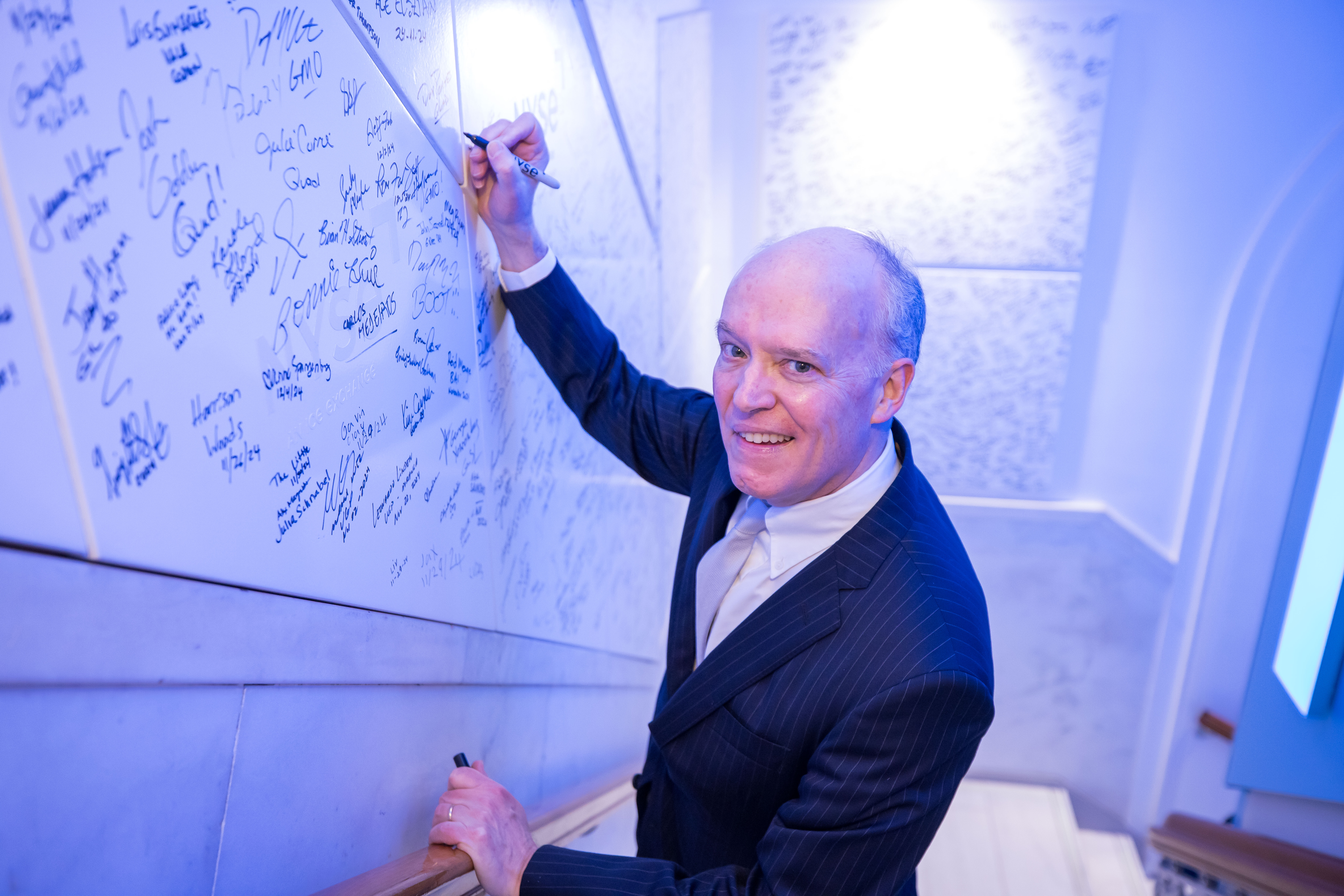 Peter G. Fitzgerald, Chairman of the Board of Chain Bridge Bank, N.A., signing the New York Stock Exchange signature wall.