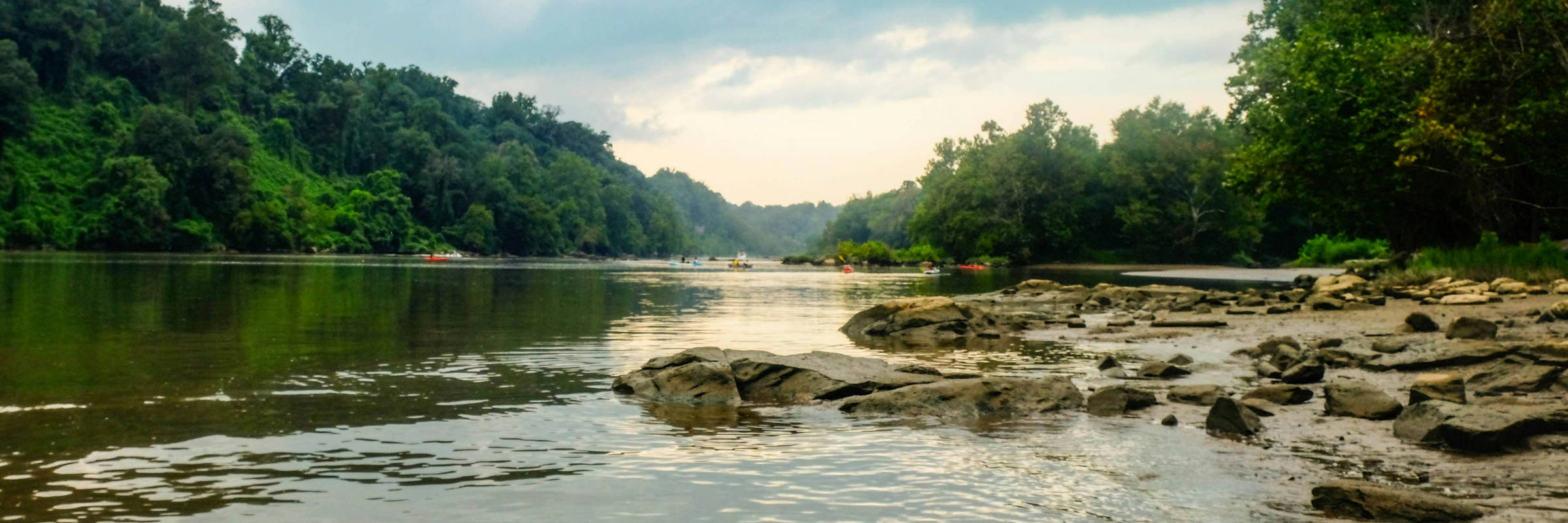 Potomac River between wooded banks, with a rocky shoreline