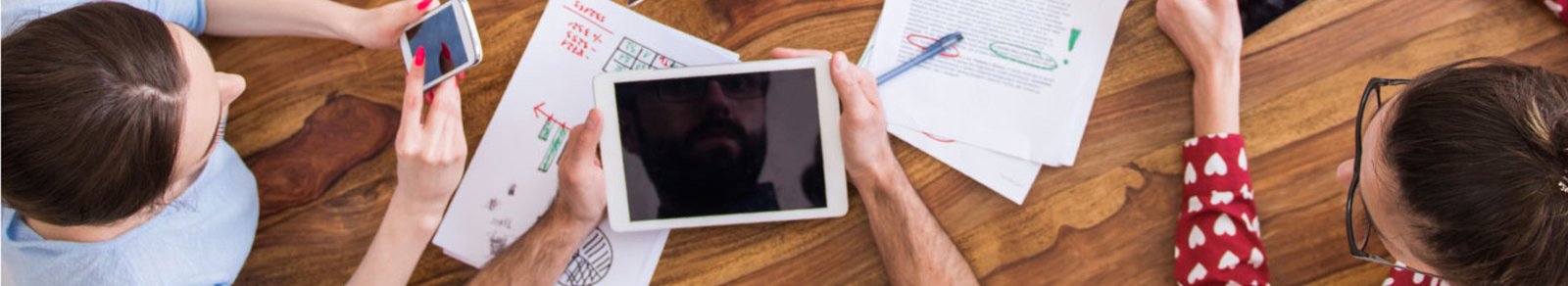 individuals hold smart devices while having a meeting